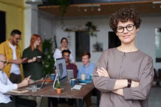 curly-haired woman with glasses - leader